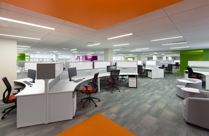 Clusters of three-, six- and nine-person workstations, with low panels and overhead storage bins, comprise the main floor. Windows surround the entire area maximizing the use of natural light. Image courtesy of BBGM.
