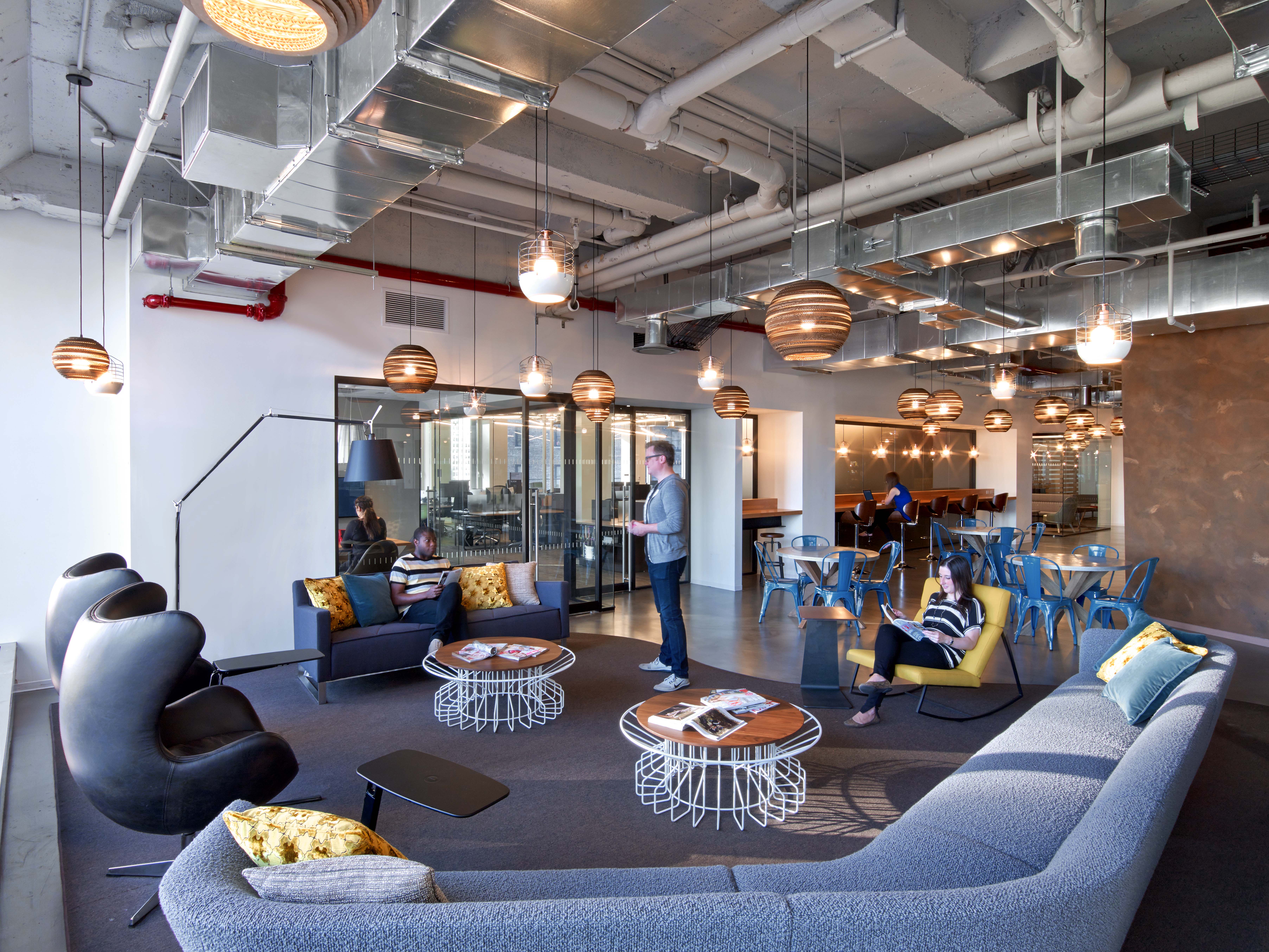 Here, TPG designed a multi-seating collaboration area incorporating soft seating with more traditional café meeting spaces. Raw, exposed materials for industrial aesthetic. Photo by Eric Laignel Photography.