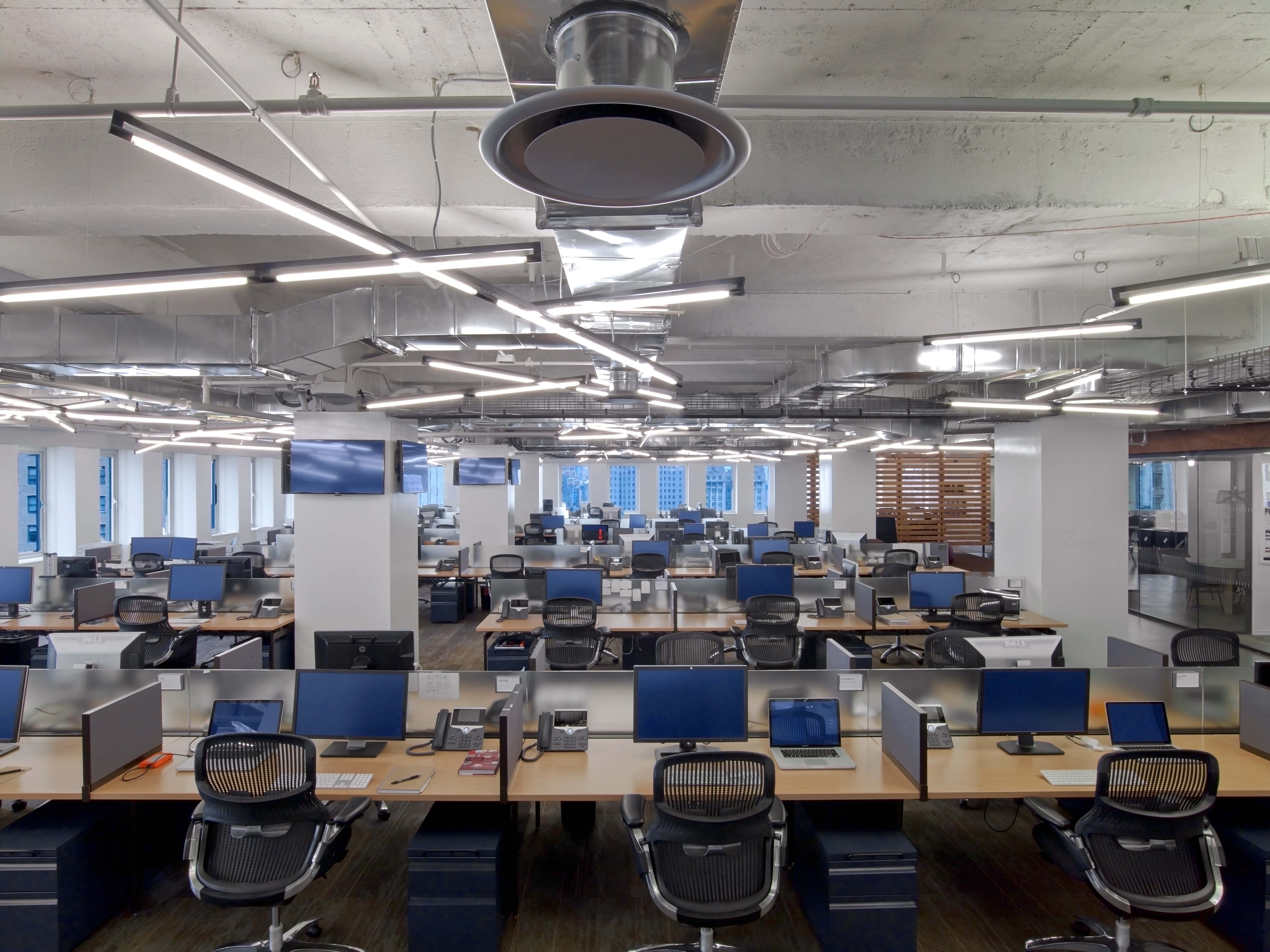 Dense, open workspace, an exposed ceiling o satisfy the desired industrial aesthetic, and non-traditional workplace lighting. Photo by Eric Laignel Photography.