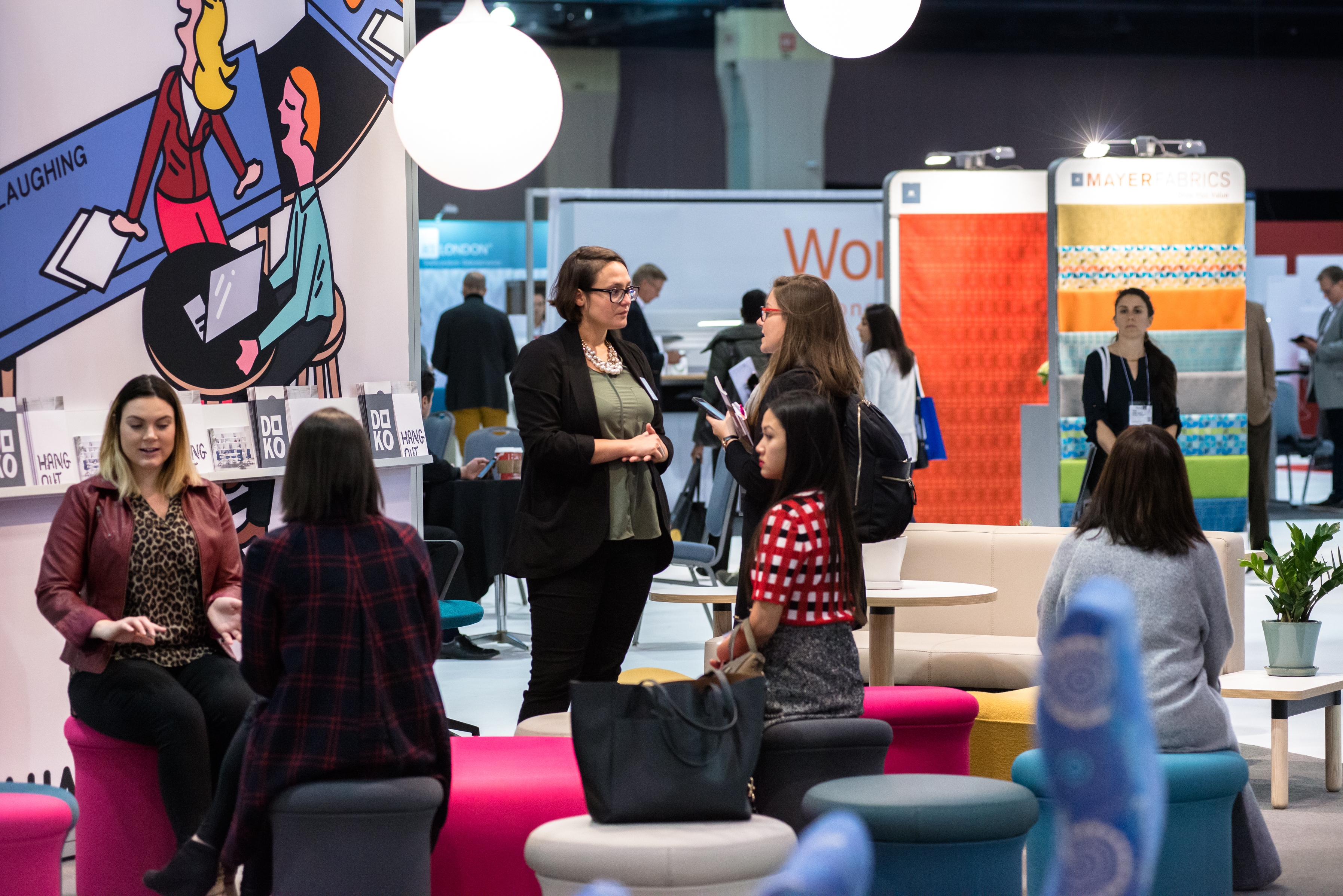 Attendees mingle in the Keilhauer booth. Image via Novita PR.