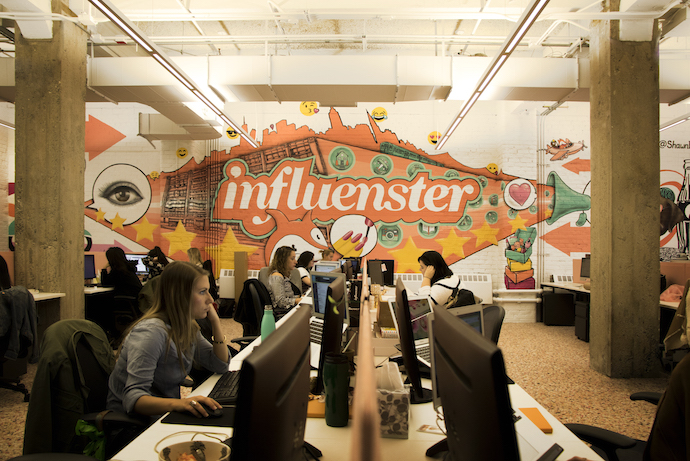 Staff work on Herman Miller desks. Image courtesy of Influenster.