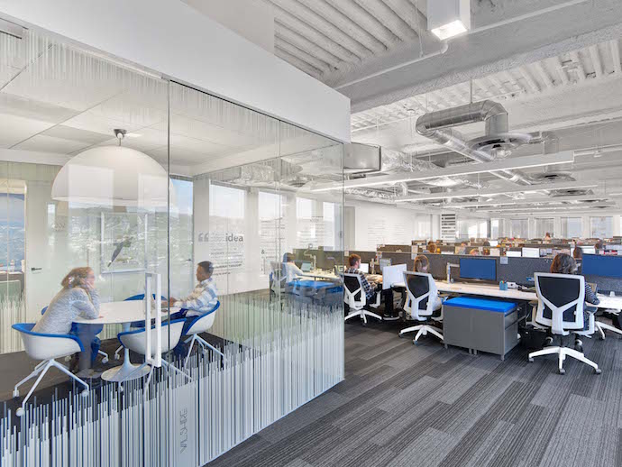 The open office features faceted huddle rooms. Image courtesy of Eric Laignel.