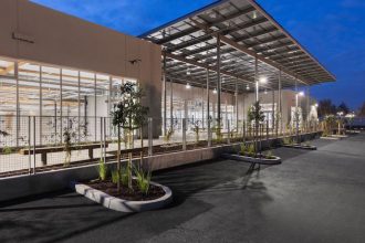 Watertight solar panels double as a trellised-portico providing an attractive, shaded entrance in all weather conditions. Image courtesy of WRNS Studio.