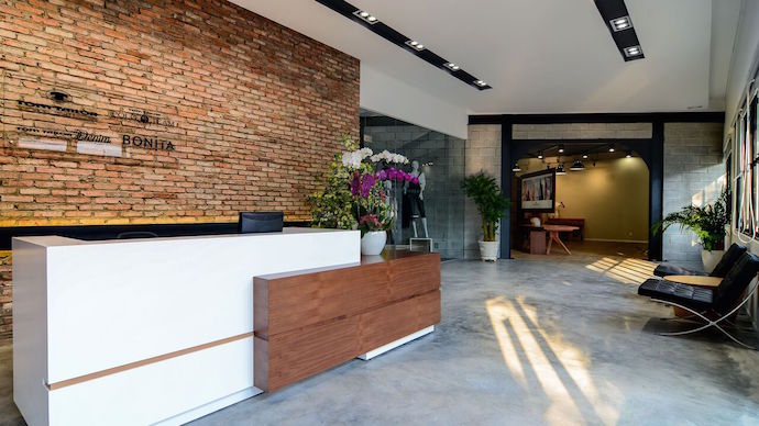 The reception area highlights outdoor materials, while large windows let in natural light and afford and views to the outside. Image courtesy of Thuc Le Photography.