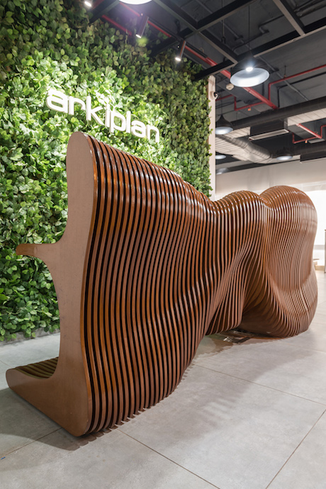 The parametric reception table is made up of 184 distinct pieces of wood. Inspired by the deep waves of the ocean, the table appears different from different angles. Image courtesy of PHX India. 