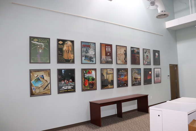 This wall displays the annual convention franchise member poster contest winners from the last 16 years. Image courtesy of Cheryl Clowes.