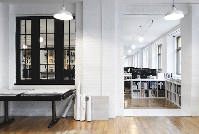 The office's brick walls give an interesting texture and an urban atmosphere, as the interior windows, remains of the past, allow the diffusion of natural light and the visual permeability between the different workspace’s zones. Image courtesy of Jessy Bernier Photographe.