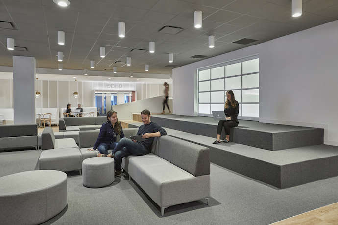 Serving as a focal point for the space is a townhall, a college-quad-like area, with moveable furniture that allows for casual meetings for groups of all sizes, and circulation to cross into other areas of the office. Image courtesy of Garrett Rowland. 